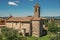 Church and bell tower with trees in Monteriggioni