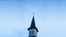 Church building. Spire of the Catholic Church with a cross. Against the background of the blue sky. Protistantism