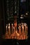 Church candles burning in candlesticks in darkness