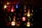 Church candles in colorful transparent chandeliers.