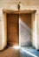 The church door almost close with light rays falling down to the