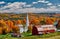 Church and farm with red barn at autumn