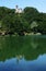 A church with its bell tower reflects on the lake of Castel dell`Alpi