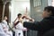 A church member lighting a candle of an altar assistant before the procession of Christ Three Falls in Madrid