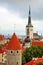 The church of Oleviste St. Olaf close up and towers of the walls of Tallinn on a cloudy day, Tallinn