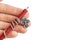 Church red candle wound on a silver cross lies on a woman`s hand on a white background