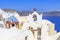 Church with red cross and green bells in Oia village, Santorini