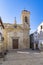 The Church of San Nicolas de Requena on a small square with benches and a water pump near Valencia, Spain