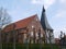 Church with sloping walls in the Alte Land Germany, nave made of brick, church tower panelled with wood