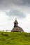 Church in the Slovenia big plateau pasture Velika Planina. Chapel on the hill, religion symbol. Green meadow and blue sky with
