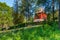 Church spire of a typical Swedish wooden church in a rural setting against a blue sky