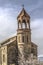 Church of St.Mesrop Mashtots with a cylindrical bell tower among flowering apricot trees