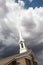 Church Steeple Tower Below Ominous Stormy Thunderstorm Clouds.