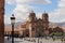 The Church of th e Society of Jesus in the Plaza de Armas in Cusco, Peru with tourists and Peruvians walking through the square