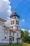 Church to St. Grand Prince Alexander Nevsky in Pudozh after restoration. Orthodox bell tower against northern pine forest and blue