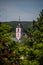 Church tower looks out between the trees