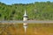 Church tower reflection in the lake of Geamana in the Apuseni Mountains, Romania