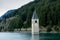 Church under water, drowned village, mountains landscape and peaks in background. Reschensee Lake Reschen Lago di Resia.