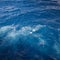 Churning blue sea water with bubbles