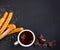 Churros with liquid chocolate. Churro - Fried dough pastry with sugar powder on black  background. Copy space