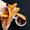 Churros with sugar dipped in chocolate sauce on a black background. Churro sticks. Fried dough pastry, top view
