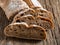 Ciabatta. Dark fresh healthy flattish open-textured Italian bread with a floury crust on wooden background. Close-up