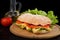 Ciabatta sandwich with lettuce , prosciutto and  cheese on wooden board