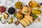 Ciabattas, olive oil in a bowl with olives, herbs, spices, garlic, pesto, parmesan and ciabatta bread on a texture background.