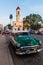 CIENFUEGOS, CUBA - FEBRUARY 10, 2016: Vintage car at Parque Jose Marti square in Cienfuegos, Cuba. Catedral de la