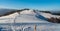 Cienkow Nizni hill with snow covered road, meadows and trees in winter Beskid Slaski mountains in Poland