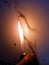 Cigarette lighter lighting flame in front of white tiles