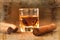 Cigars and whisky on old wooden table.