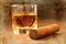 Cigars and whisky on old wooden table.