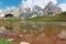 Cimon della Pala among rugged peaks of Pale di San Martino reflecting on a mountain lake