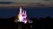 Cinderella\'s Castle lit up in rainbow colors.