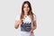 Cinema concept. Attractive young woman with long hair, holds clapperboard, has red manicure, dressed in casual t shirt, models ind