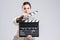 Cinema Concepts and Ideas. Portrait of Female Film Director Posing with Actioncut. Against Gray Background