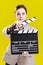 Cinema Concepts and Ideas. Portrait of Female Film Director Posing with Actioncut. Against Yellow Background