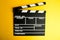 Cinema minimal concept. Watching film in the cinema. clapper board on yellow background