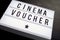 Cinema voucher on word board in movie theme
