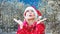 Cinemagraph of blond woman dressed as Santa Claus outdoors in a snowy forest