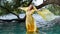 Cinemagraph of blond woman in yellow historic dress standing in the water