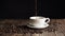 Cinemagraph. Coffee cup and coffee beans. White cup of evaporating coffee on the table with roasted bean. Slow Motion