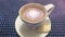 Cinemagraph - Galaxy in the cup of coffee. Steaming white cup of coffee with rotating galaxy in it on a table with a