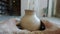 Cinemagraph loop of beautiful vase made of clay rotating in craftsman`s hands in workshop