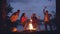 Cinemagraph loop - joyful friends multiethnic group are dancing around fire in forest during weekend trip. Young people