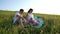 Cinemagraph pregnant couple with toddler daughter have leisure time outdoors in grass field