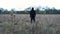 A cinemagraph of a spooky hooded figure standing in a field on a winters day