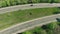 Cinematic aerial tracking shot of a single vehicle entering the city.