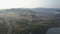 Cinematic Aerial view of a railway station in mountains next to a lake. Foggy Sunrise In Mountains.